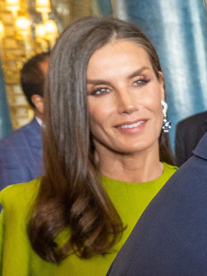 Retrato de la reina Letizia, sonriente, con vestido verde